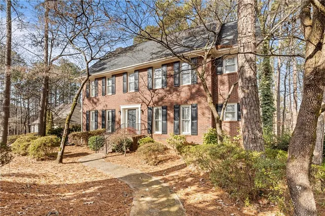 a view of a white house next to a road