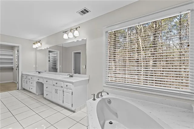 a bathroom with a granite countertop sink and a bathtub