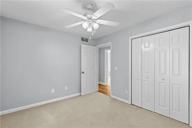 an empty room with a chandelier fan and a ceiling fan