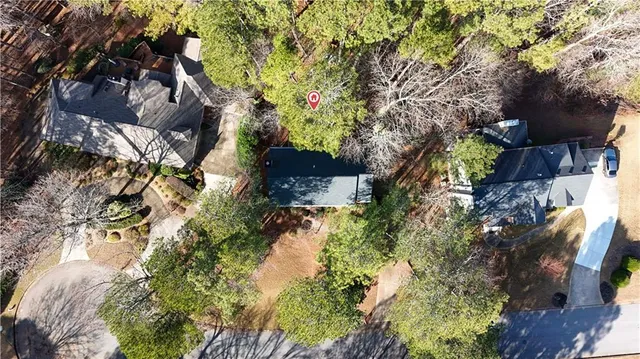 a aerial view of a house with a yard and large trees