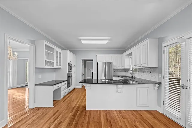 a kitchen with kitchen island white cabinets and stainless steel appliances