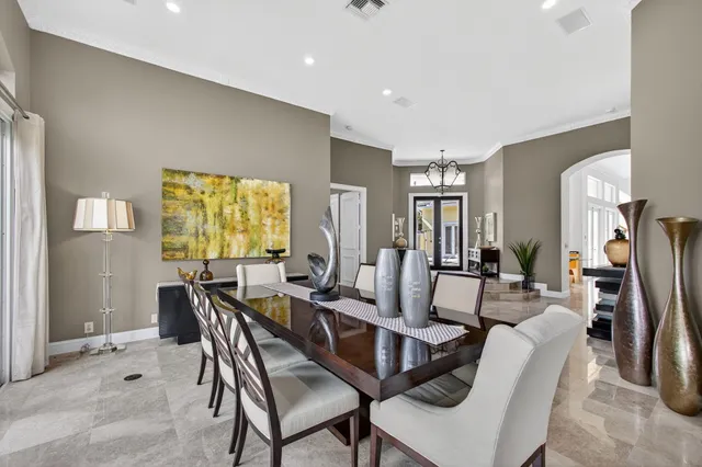 a view of a dining room with furniture a chandelier and kitchen view