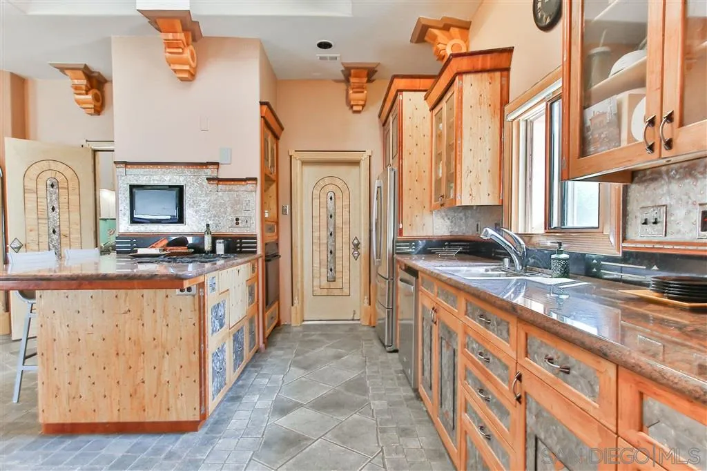 2908 Sumac Road Fallbrook, CA 92028 - Photo 7 of 23 a large kitchen with stainless steel appliances granite countertop a sink and a stove next to a large window