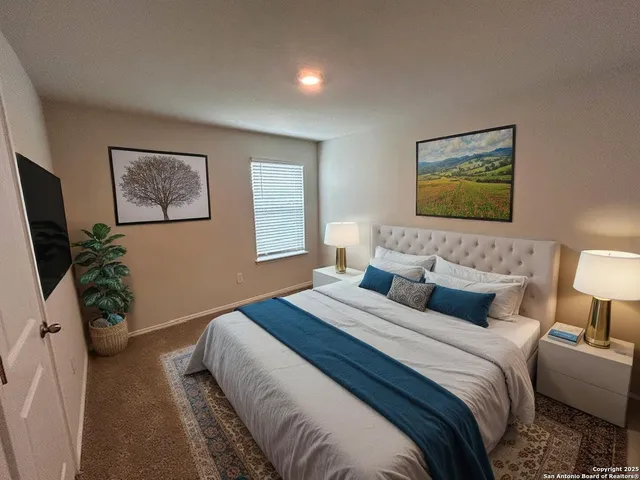 a bedroom with bed and a painting on the wall