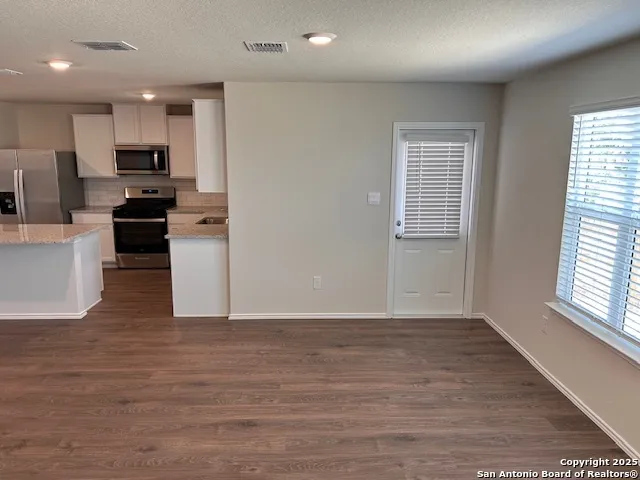 a view of kitchen with wooden floor electronic appliances and window