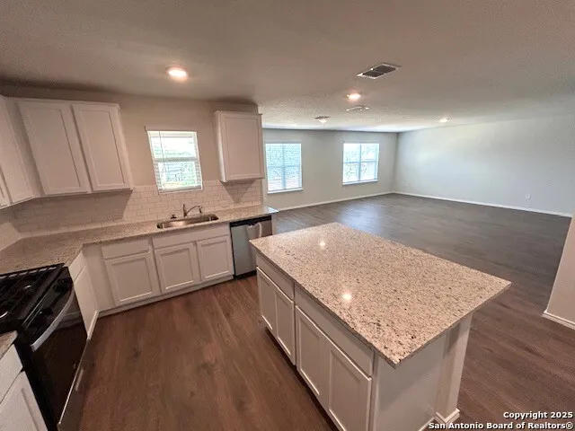 a kitchen with a sink stove and cabinets