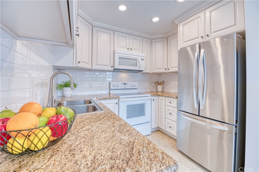 33782 Malaga Drive, Unit A Dana Point, CA 92629 - Photo 4 of 17 a kitchen with stainless steel appliances granite countertop a refrigerator sink and cabinets