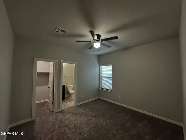 an empty room with a window and a fan