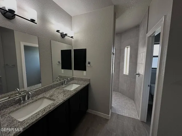 a bathroom with a granite countertop sink and a mirror