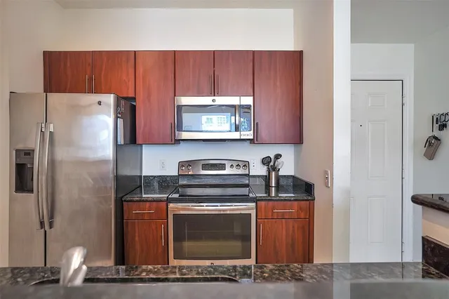 a kitchen with stainless steel appliances granite countertop a refrigerator stove and microwave