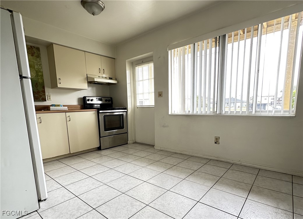 4613 Southwest 8th Place, Unit 4 Cape Coral, FL 33914 - Photo 3 of 16 a kitchen with stainless steel appliances granite countertop a stove a sink and a refrigerator