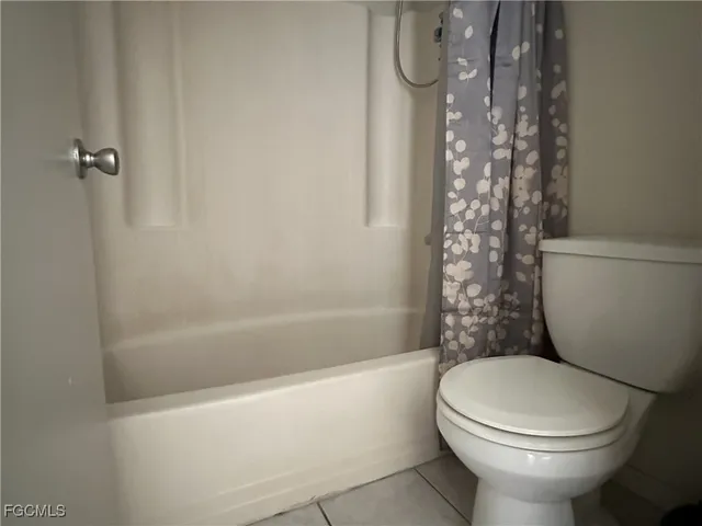 a white toilet sitting next to a bath tub and shower