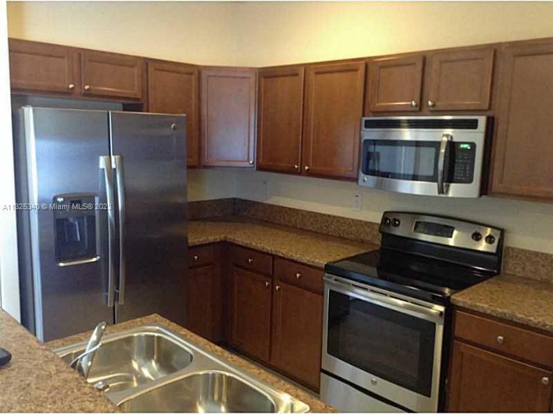 8946 West 35th Way Hialeah, FL 33018 - Photo 12 of 25 a kitchen with granite countertop a refrigerator stove and microwave