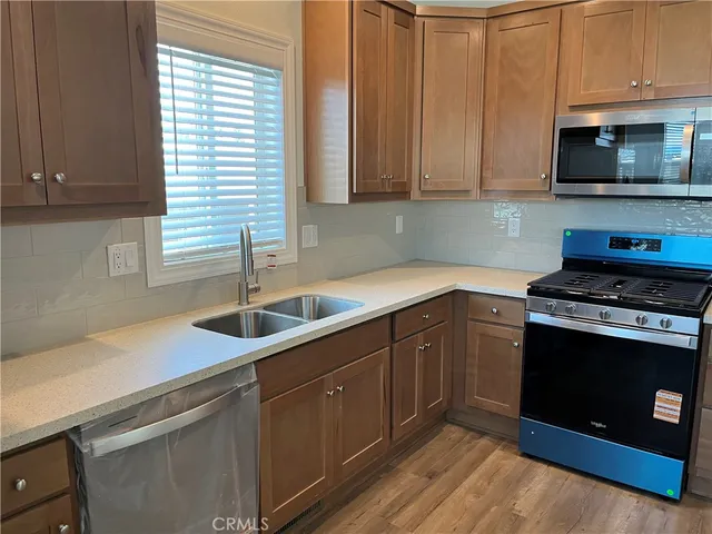 a kitchen with stainless steel appliances granite countertop a sink a stove a microwave and cabinets