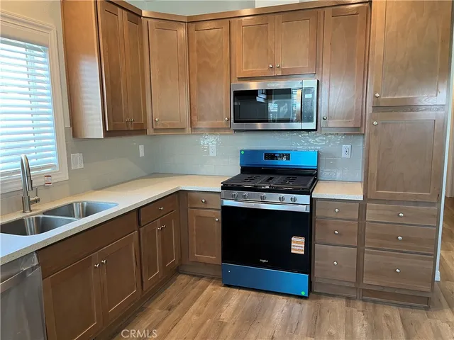 a kitchen with stainless steel appliances granite countertop a stove a microwave and a sink