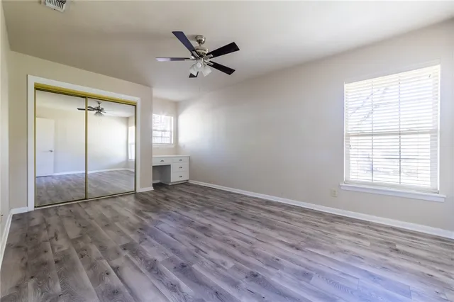 a view of empty room with wooden floor and window