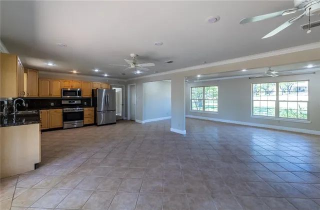 a view of a livingroom with kitchen appliances and a window
