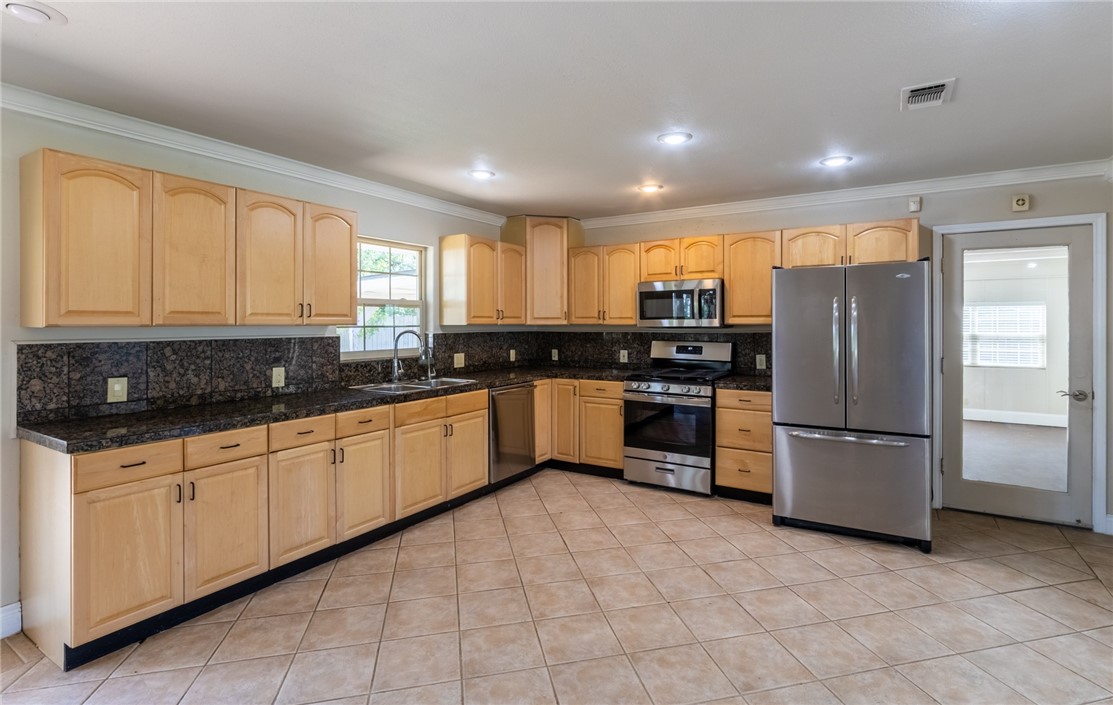 11801 Bell Avenue Austin, TX 78759 - Photo 4 of 31 a kitchen with granite countertop a refrigerator and wooden cabinets