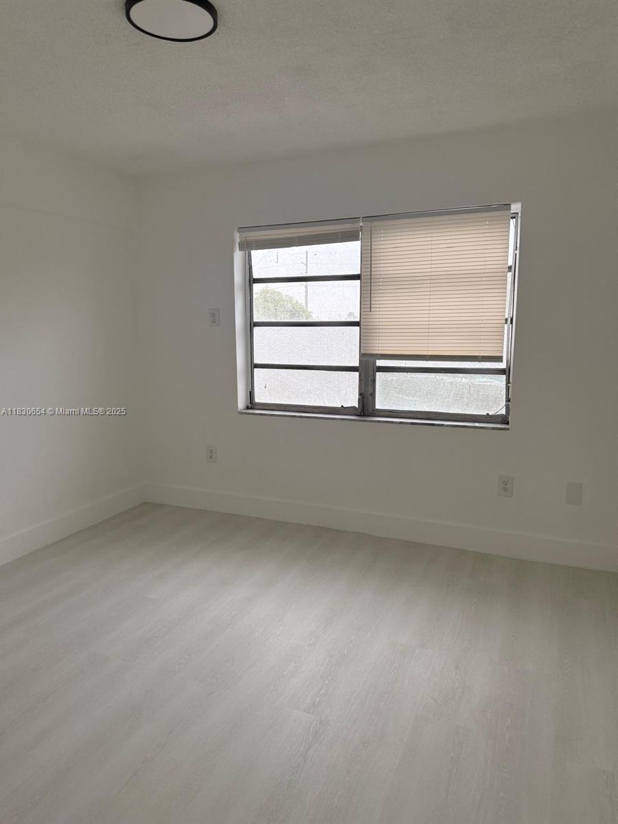 1000 West 28th Street, Unit 15 Hialeah, FL 33010 - Photo 4 of 10 an empty room with a window