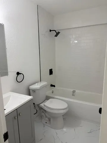 a white toilet sitting next to a bath tub