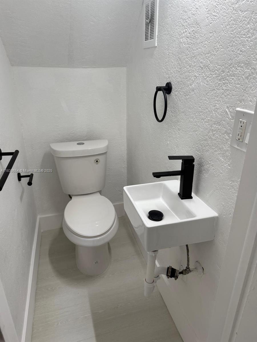 1000 West 28th Street, Unit 15 Hialeah, FL 33010 - Photo 7 of 10 a bathroom with a toilet sink and mirror