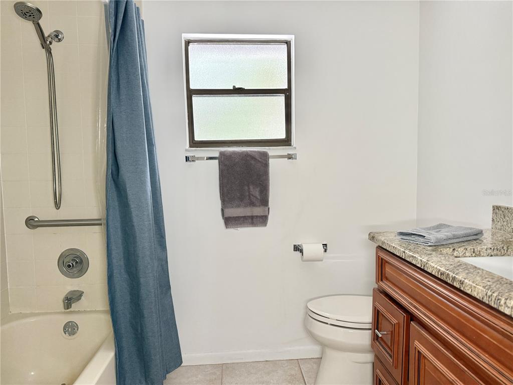 6101 Soaring Avenue Temple Terrace, FL 33617 - Photo 24 of 53 a bathroom with a granite countertop toilet sink and mirror