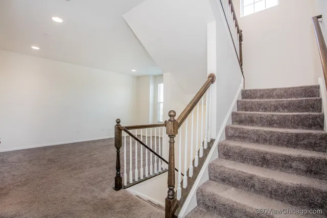 a view of staircase with wooden floor and white walls