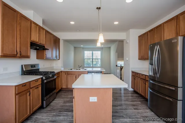 a large kitchen with stainless steel appliances granite countertop a sink stove and refrigerator
