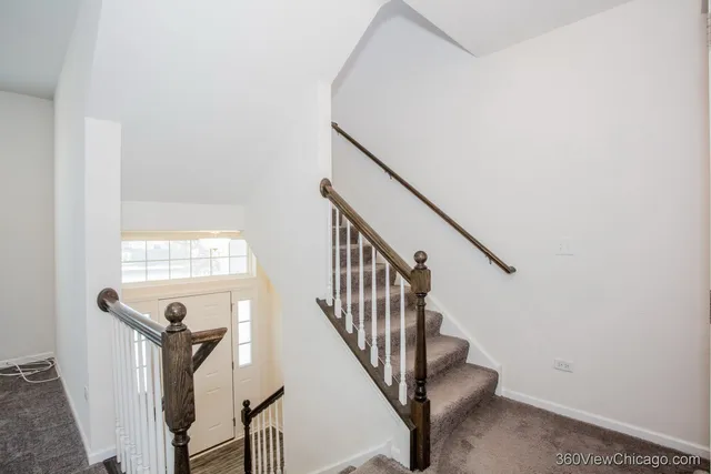 a view of a hallway with wooden floor and entryway