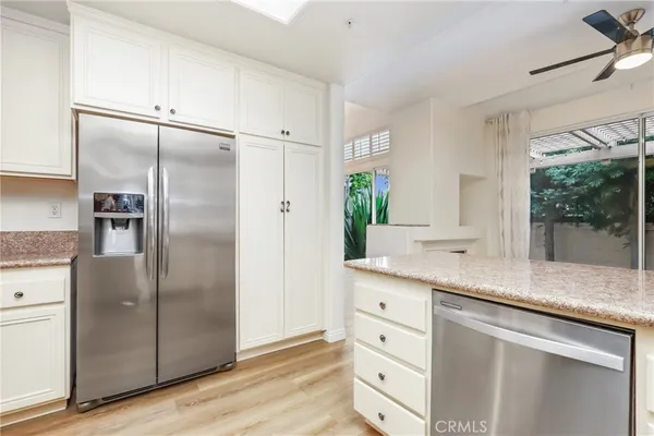 a kitchen with granite countertop a refrigerator and cabinets