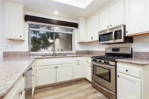 a kitchen with stainless steel appliances granite countertop a stove microwave and sink