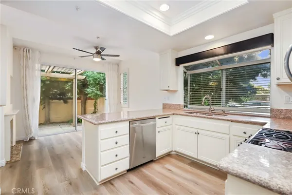 a large kitchen with cabinets wooden floor and a sink