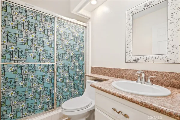 a bathroom with a granite countertop sink toilet and shower