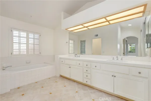 a bathroom with a tub sink and mirror