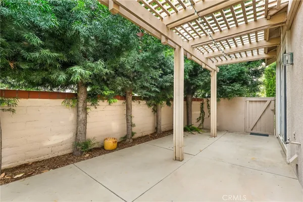 a view of backyard with large tree and wooden fence