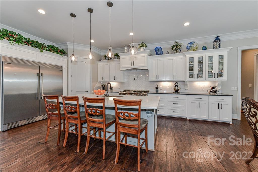 9625 Kerr Road Indian Trail, NC 28079 - Photo 11 of 48 a kitchen with stainless steel appliances kitchen island granite countertop a table chairs sink and cabinets