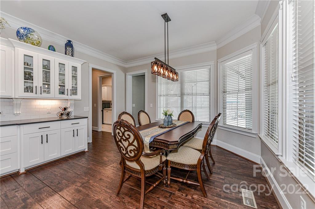 9625 Kerr Road Indian Trail, NC 28079 - Photo 15 of 48 a dining room with furniture a chandelier and wooden floor