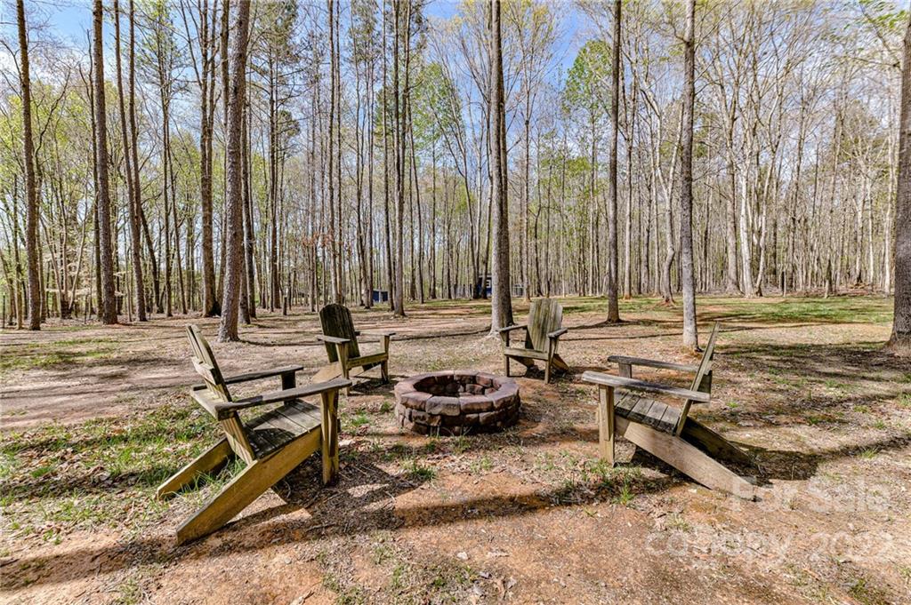 9625 Kerr Road Indian Trail, NC 28079 - Photo 44 of 48 a backyard of a house with lawn chairs pool table and chairs
