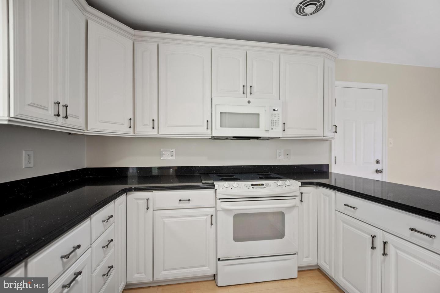 705 Halstead Road Wilmington, DE 19803 - Photo 9 of 31 a kitchen with granite countertop white cabinets and white appliances
