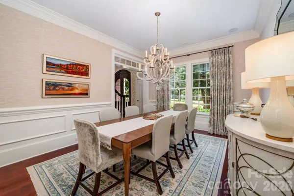 a view of a dining room with furniture a chandelier and wooden floor