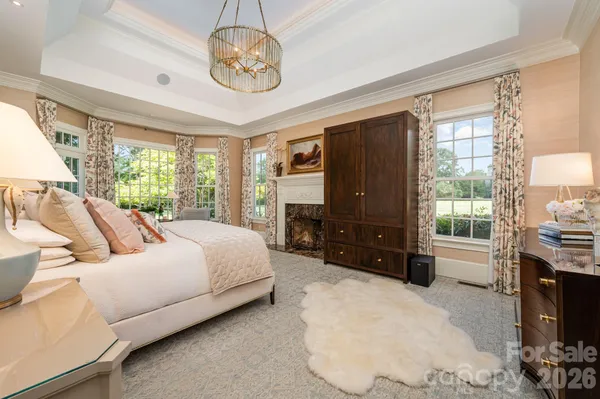 a bedroom with a bed flat screen tv and a fireplace