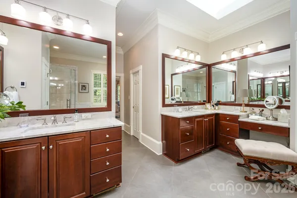 a bathroom with a granite countertop double vanity sink and a mirror