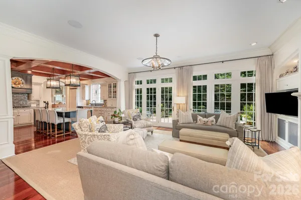 a living room with furniture a flat screen tv and a large window