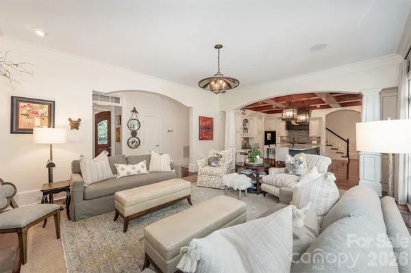a living room with furniture a chandelier and a flat screen tv