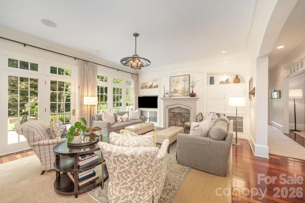 a living room with fireplace furniture and a chandelier