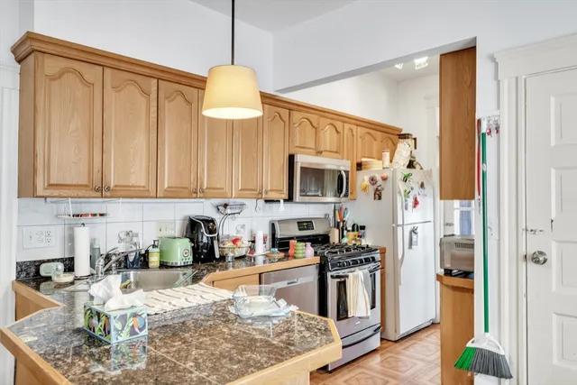a kitchen with stainless steel appliances granite countertop a sink a stove and a refrigerator