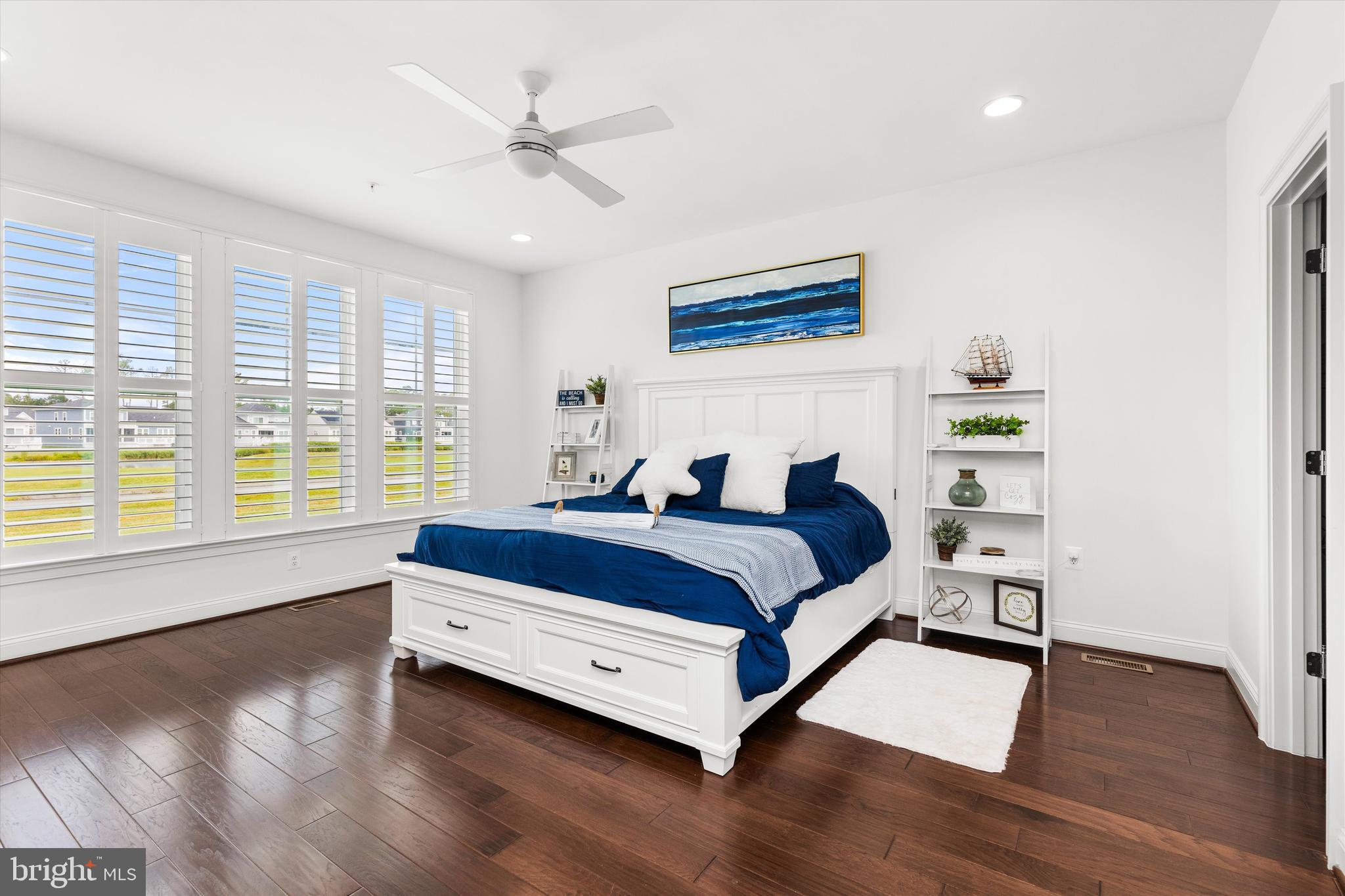 10119 Fast Colors Lane Berlin, MD 21811 - Photo 22 of 43 a bedroom with a bed and a large window with wooden floor