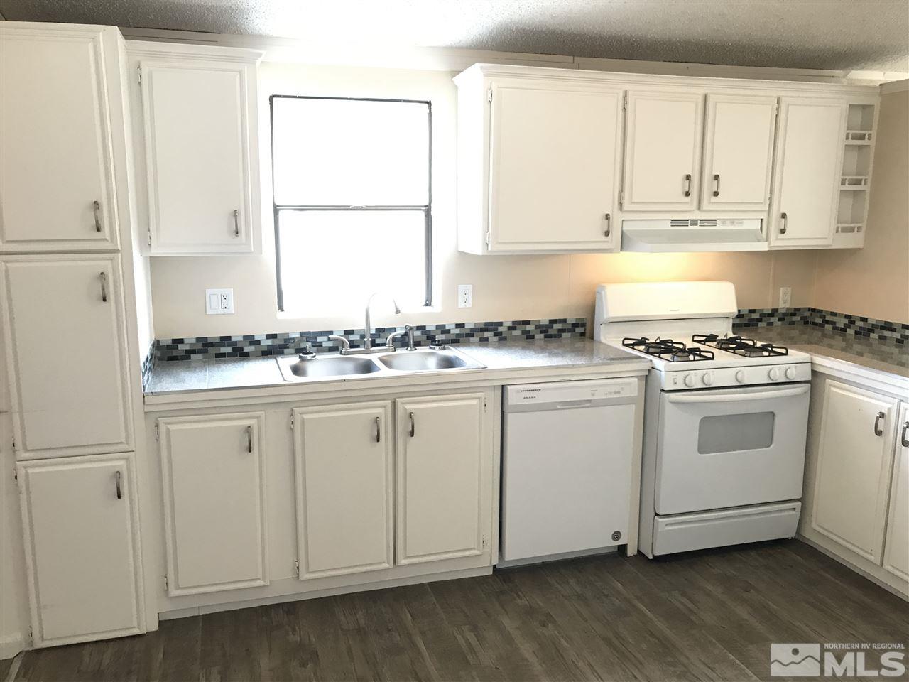 1890 Collins Circle Reno, NV 89506 - Photo 9 of 21 a kitchen with granite countertop white cabinets and white appliances