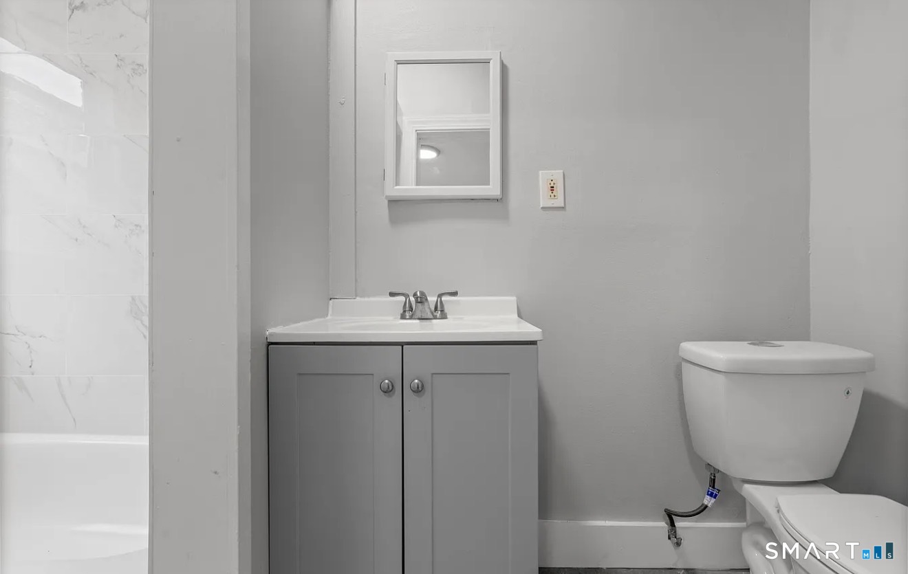 25 Whittier Street, Unit 3 Bridgeport, CT 06605 - Photo 2 of 7 a bathroom with a toilet sink and mirror