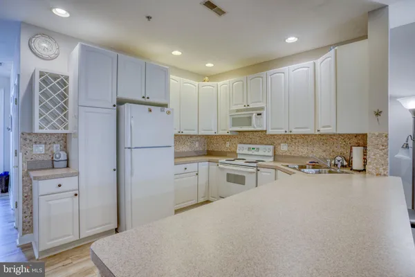 a kitchen with a sink dishwasher and white cabinets